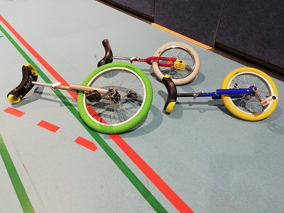 drei Einräder liegen auf dem Hallenboden