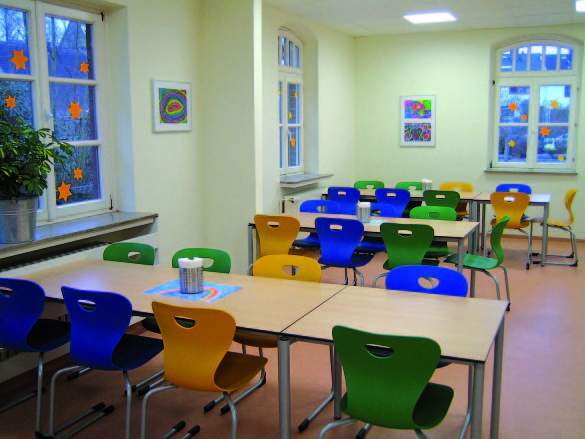 das Foto bietet einen Blick in die Mensa, es sind Tische und Stühle zu sehen