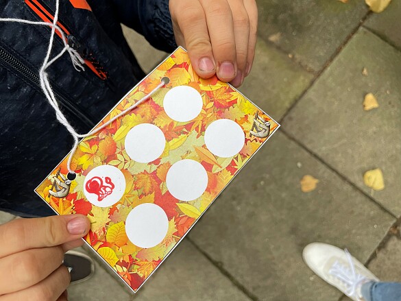 Das Foto zeigt eine Stationenstempelkarte in einer Kinderhand