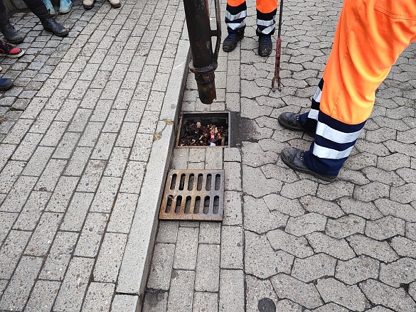 Ein Gully wird von einem Schlauch gereinigt.