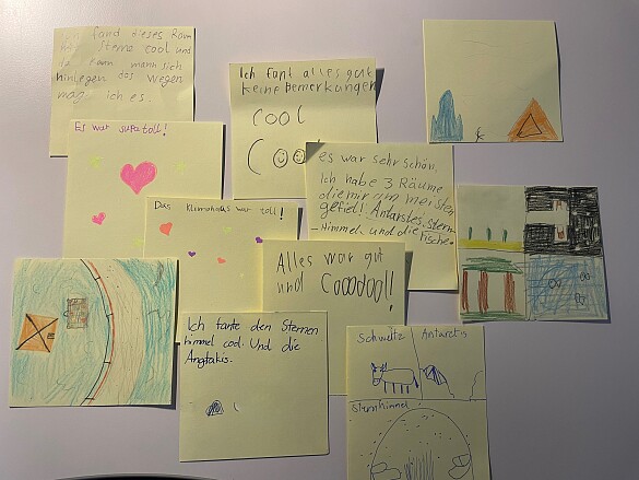 Das Foto zeigt viele gelbe Klebezettel mit Bemerkungen und Kommentaren zum Schulausflug von Kindern.